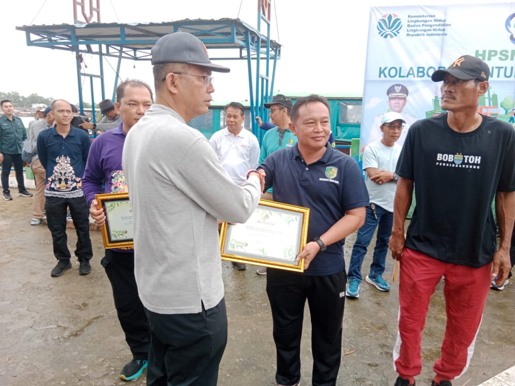 Pj Wali Kota Palangka Raya, Akhmad Husain, menyerahkan penghargaan Proklim kepada perwakilan warga dalam peringatan Hari Peduli Sampah Nasional di Pelabuhan Rambang, Selasa (18/2/2025).